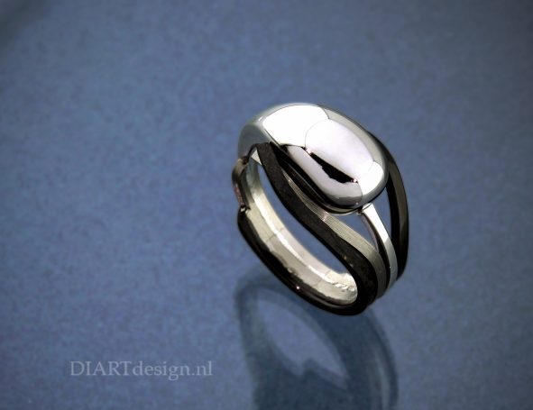 Urn ring uit witgoud, titanium en zwart zirconium.